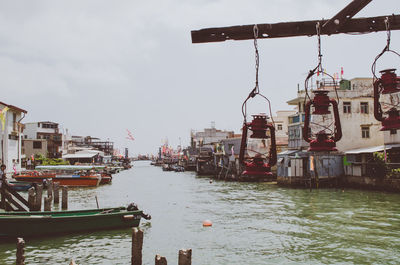 Boats moored at harbor against sky