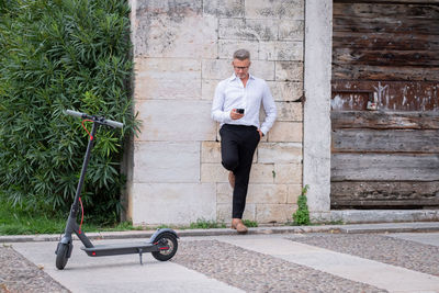 Young businessman using phone near electric scooter. focus on scooter