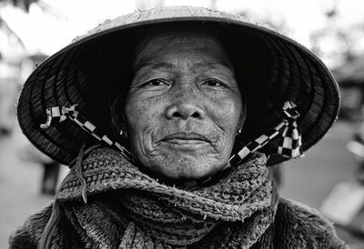 Close-up portrait of senior woman wearing asian style conical hat