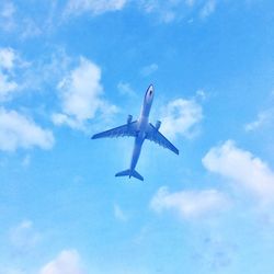 Low angle view of airplane flying against sky