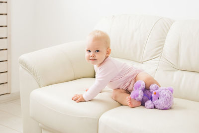 Cute girl sitting on sofa at home