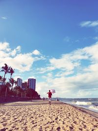 Woman standing on beach against sky