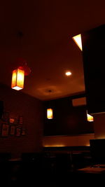 Low angle view of illuminated pendant lights hanging from ceiling