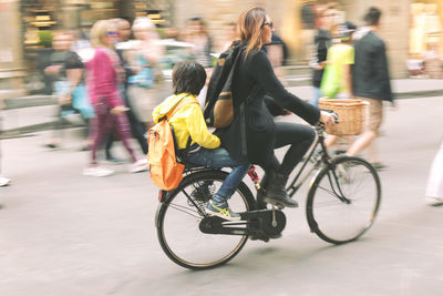 Man with bicycle on road in city