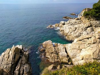 High angle view of cliff by sea against sky