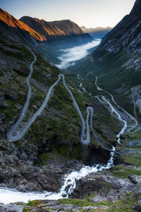 Scenic view of stream flowing amidst mountains against sky