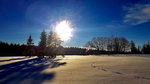 Scenic view of snowcapped landscape against sky on sunny day