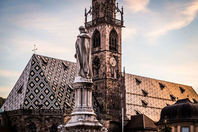 Low angle view of statues on building against sky