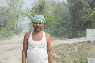 Portrait of smiling man standing against trees