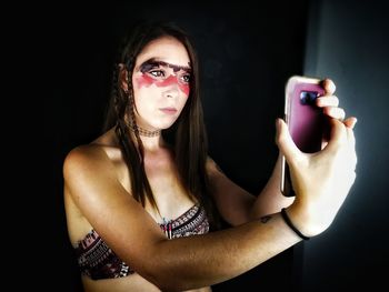 Young woman with face paint taking selfie