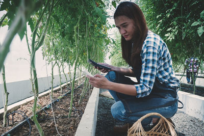 Full length of young man sitting on plant