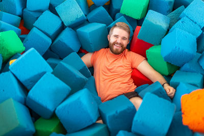 Portrait of smiling man sitting on multi colored indoors