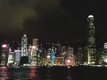 Illuminated buildings against sky at night