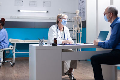 Doctor wearing mask examining patient