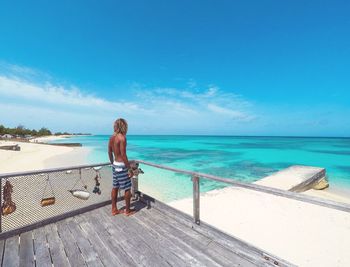 Rear view of man standing in balcony against sea