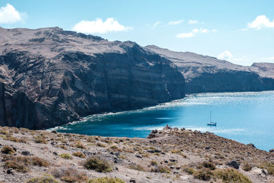 Scenic view of sea and mountains against sky