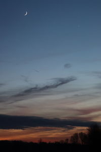 Low angle view of silhouette moon against sky at sunset