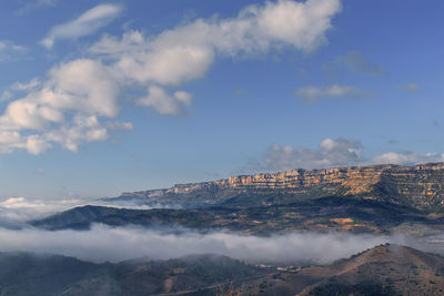 Aerial view of mountain range against cloudy sky