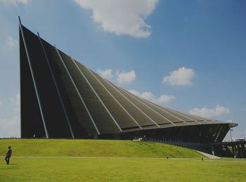 Low angle view of modern building against cloudy sky