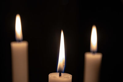 Close-up of candles burning in darkroom