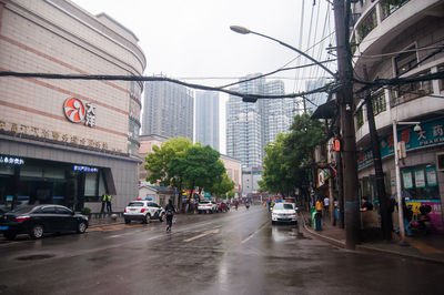 City street amidst buildings during rainy season