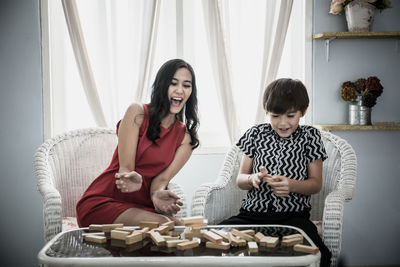 Mother and son playing with wooden blocks at home