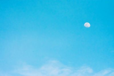 Low angle view of moon against blue sky