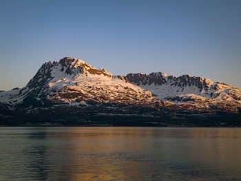 Scenic view of lake and mountains against clear sky