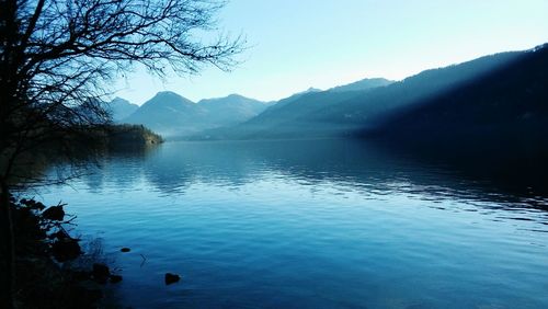 Scenic view of lake by mountains against sky