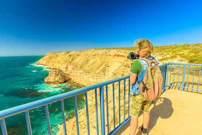 Man photographing sea at kalbarri national park on sunny day