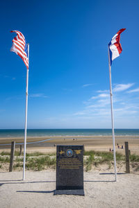 Lifeguard hut on beach against blue sky