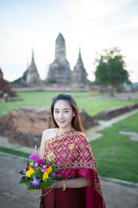 Portrait of beautiful woman standing at temple