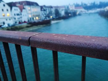 Close-up of railing by sea in city