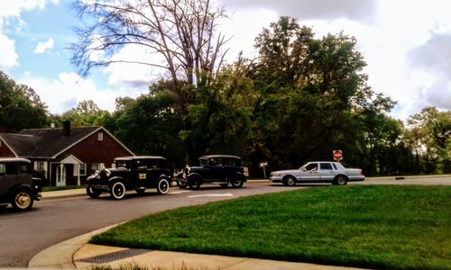 Cars on road against sky in city