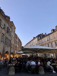 People on street by buildings against sky