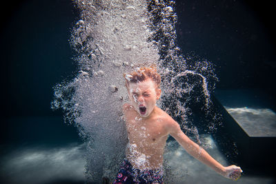 Portrait of shirtless man swimming in sea