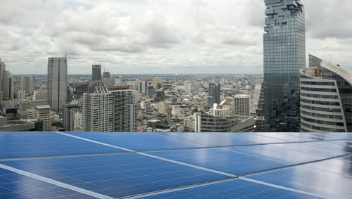 Aerial view of many photo voltaic solar panels mounted of industrial building roof.