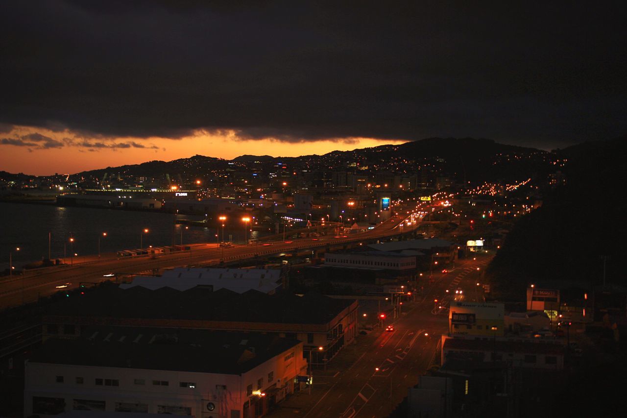 illuminated, night, building exterior, architecture, built structure, sky, city, high angle view, cityscape, residential building, residential structure, dusk, cloud - sky, lighting equipment, residential district, mountain, city life, outdoors, transportation, street light