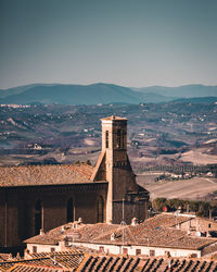 Buildings against sky with mountain in background