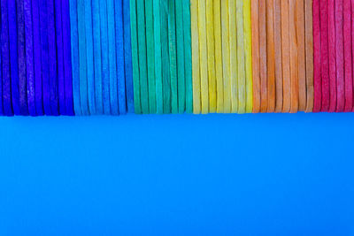 Close-up of colored pencils over blue background