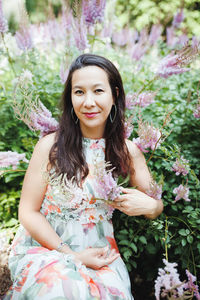 Happy mixed-race japanese woman in romantic floral maxi dress in summer park