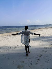 Rear view of man standing on beach