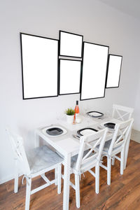 Empty chairs and table against white background