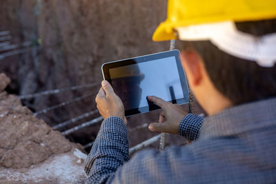 Midsection of man using mobile phone