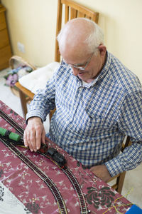 Senior man with his model railway at home