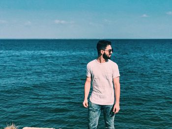 Man standing against sea and sky during sunny day