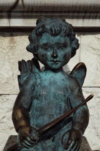 Close-up of old statue against wall