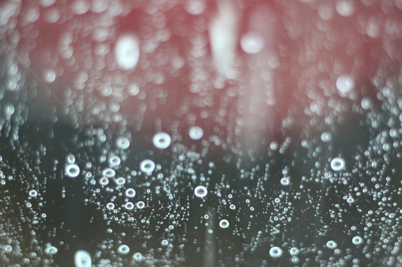 FULL FRAME SHOT OF RAINDROPS ON WET WINDSHIELD