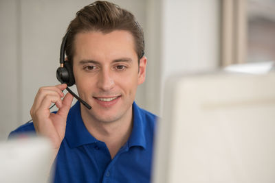 Male customer representative talking over headset in office