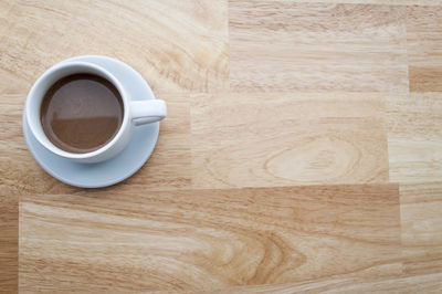 High angle view of coffee cup on wooden table